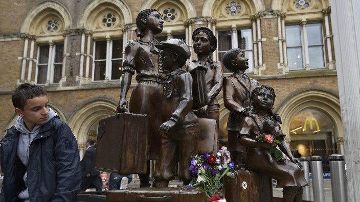 A traveller looks toward the Kindertransport memorial outside of Liverpool Street Station in London