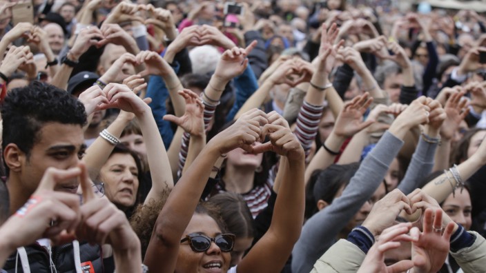 Rassismus: Menschen demonstrieren in Mailand gegen Rassismus und formen ihre Hände zum Herz-Symbol.