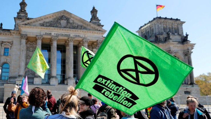 FILE PHOTO: Climate change activists attend an Extinction Rebellion protest in front of the seat of the lower house of parliament Bundestag at the Reichstag building in Berlin