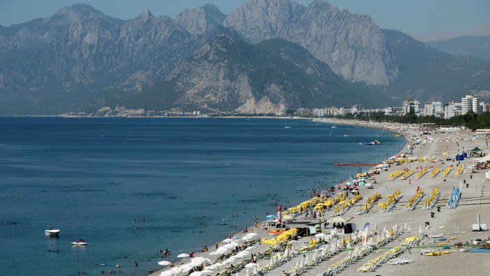 Touristen liegen im türkischen Badeort Antalya am Strand.