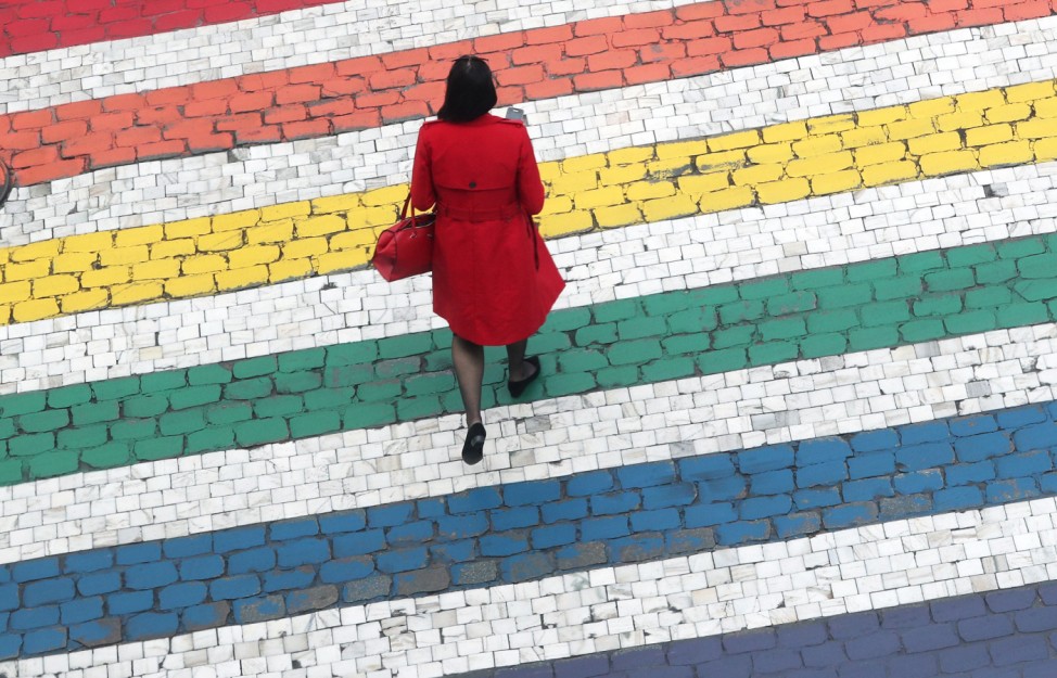 Woman crosses a road outside the EU Parliament ahead of the EU elections in Brussels