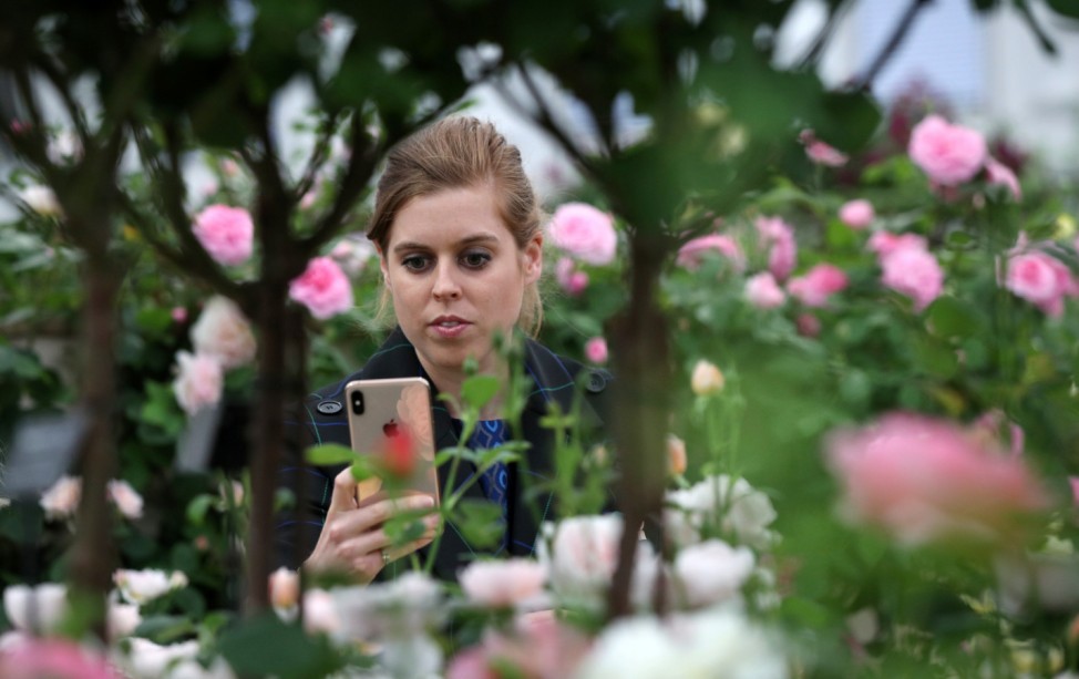 Britain's Princess Beatrice of York looks at a mobile phone while attending the Chelsea Flower Show in London