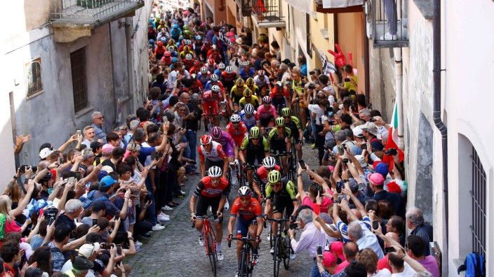 Kommentar: Rund um das Peleton (hier in den Gassen von Pinerolo beim Giro) drängen sich vorbelastete Akteure.