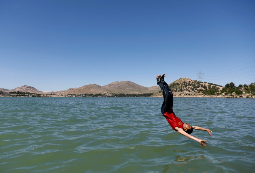 An Afghan man jumps for a swim at Qargha lake in Kabul, Afghanistan