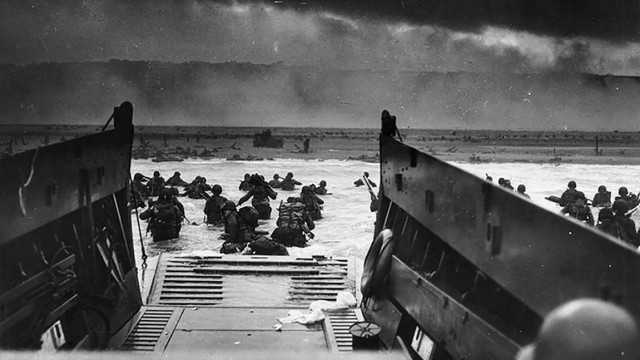 Reise nach England, Jersey und Frankreich: Ein Bild vom 6. Juni 1944 zeigt US-Soldaten, die am Omaha Beach an Land waten.