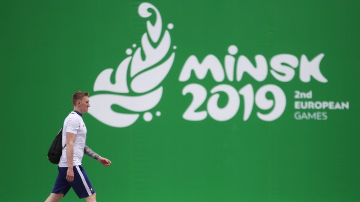 MINSK BELARUS JUNE 20 2019 A man walking by a banner at the Athletes Village ahead of the Mins
