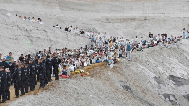 Klimaschutz: Climate activists sit on the ground after entering the Garzweiler brown coal mine in Garzweiler, western Germany, on June 22, 2019, during a weekend of massive protests in a growing 'climate civil disobedience' movement. - Anti-coal activists try to occupy the Garzweiler open-cast lignite mine in a protest to demand action against global warming, now one of the hottest issues on the European political agenda. (Photo by INA FASSBENDER / AFP)