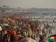 Palestinians enjoy themselves along the shore of the Mediterranean Sea as they escape from the summer heat, in Gaza City