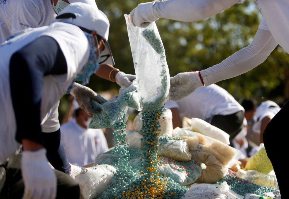 Representatives of Cambodia's authorities prepare confiscated drugs for burning during a ceremony to mark the International Day against Drug Abuse and Illicit Trafficking, in Phnom Penh