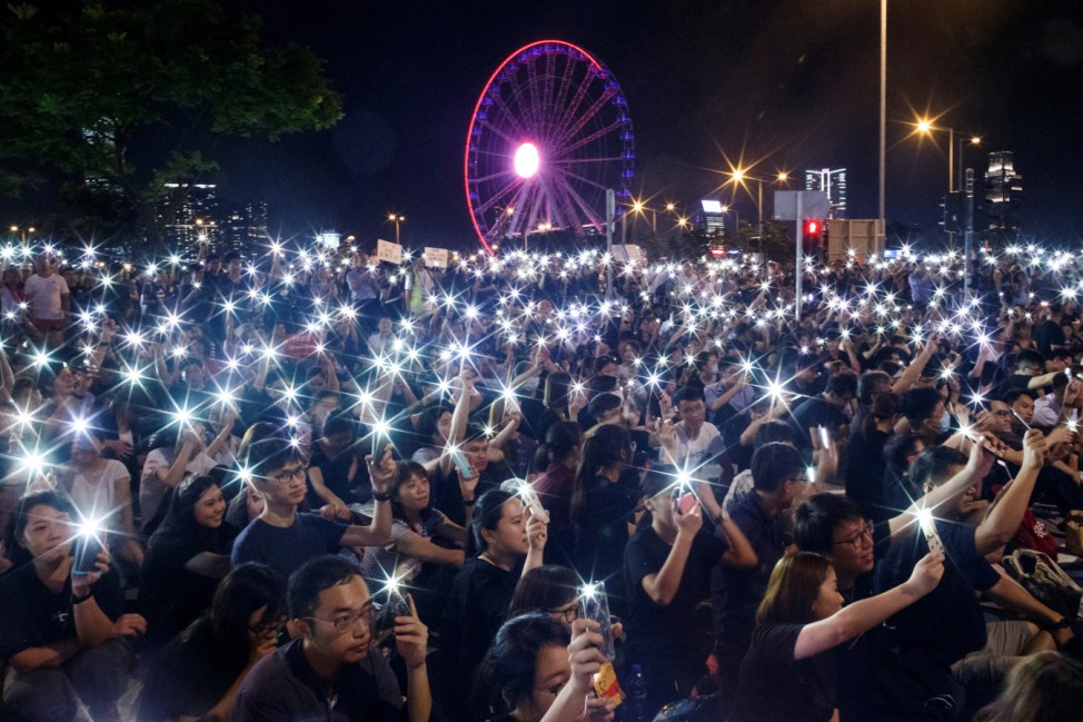 Demonstrators wave their smartphones during a rally ahead of the G20 summit, urging the international community to back their demands for the government to withdraw a the extradition bill in Hong Kong