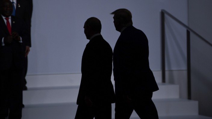 Trump und Putin bei G-20: TOPSHOT - US President Donald Trump (R) walks with Russia's President Vladimir Putin before taking a family photo at the G20 Summit in Osaka on June 28, 2019. (Photo by Brendan Smialowski / AFP)