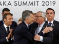 Argentina's President Mauricio Macri speaks to European Commission President Jean-Claude Juncker during a news conference at the G20 summit in Osaka