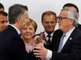 Argentina's President Mauricio Macri speaks to European Commission President Jean-Claude Juncker during a news conference at the G20 summit in Osaka
