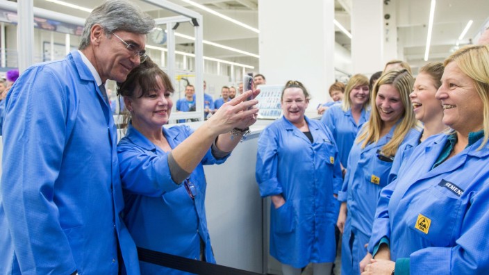 Konzerne: Joe Kaeser posiert während des Besuchs einer Siemens-Fabrik im bayerischen Amberg mit Mitarbeiterinnen für ein Selfie: Er ist seit 40 Jahren im Unternehmen, jetzt wird er seinen Vertrag nicht mehr verlängern.