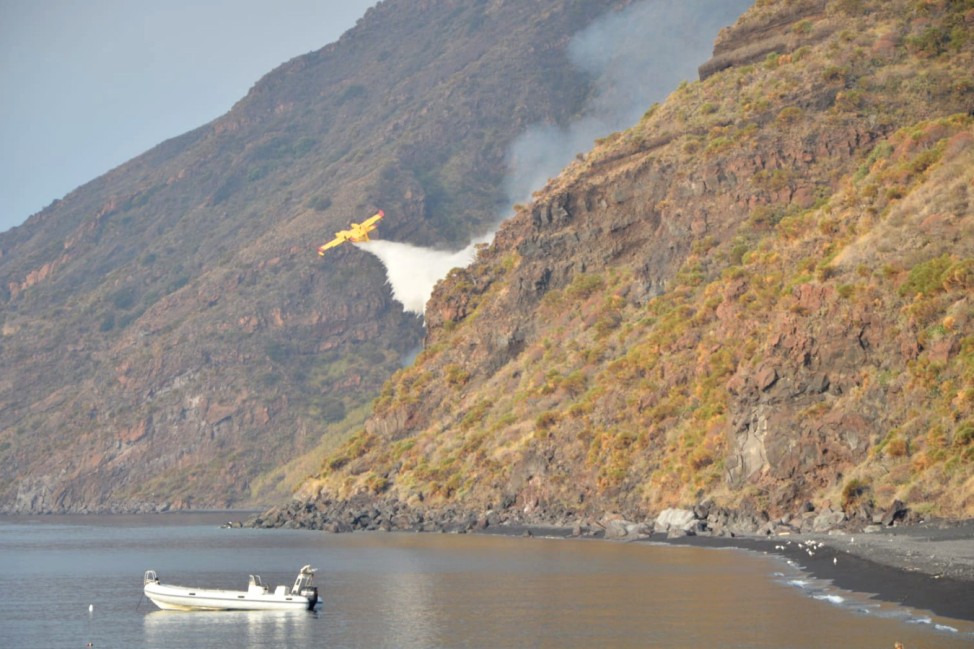 A Canadair plane drops water after the Stromboli volcano eruption started forest fires, in Stromboli