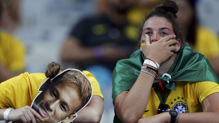 Fans of Brazil react after their loss to Germany in their 2014 World Cup semi-finals at the Mineirao stadium in Belo Horizonte