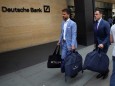 People carry bags outside a Deutsche Bank office in London