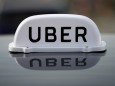 FILE PHOTO: The Logo of taxi company Uber is seen on the roof of a private hire taxi in Liverpool