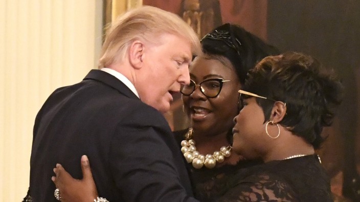 President Donald Trump embraces conservative commentators Diamond and Silk Lynette Haradaway and R