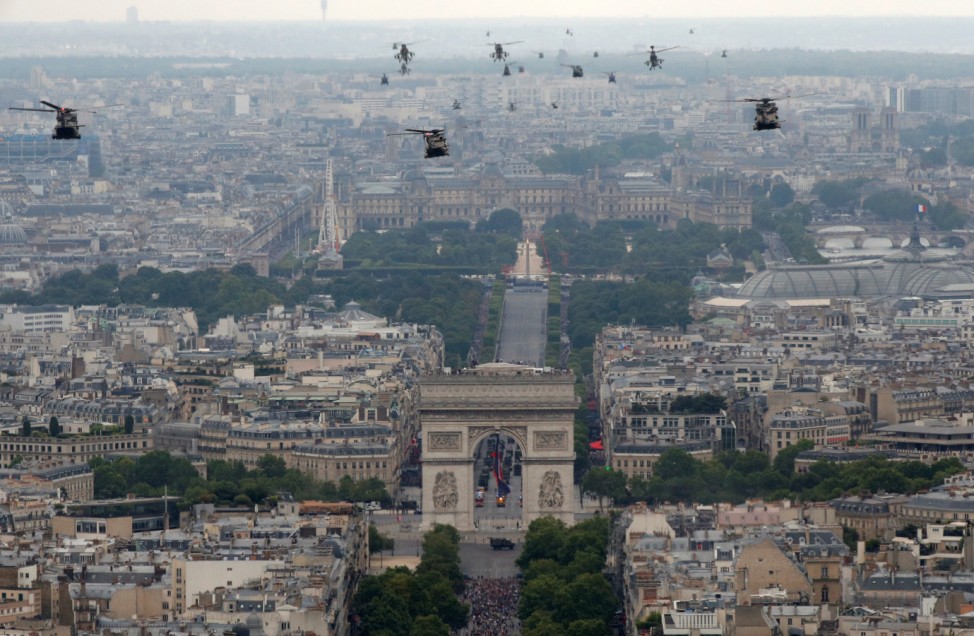Helicopters fly over the Champs-Elysees Avenue and the Arc de Triomphe during the traditional Bastille Day military parade in Paris