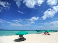 Urlauber liegen in Florida unter Sonnenschirmen am Strand.