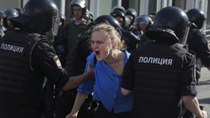 Eine junge Demonstrantin wird in Moskau von Polizisten abgeführt.