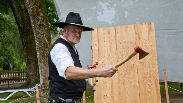 Cowboy-Festival: Roland Tirschner alias "Lucky" zimmert fünf Äxte in einer Reihe direkt nebeneinander in eine Holzwand.