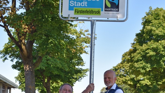 Fürstenfeldbruck: OB Erich Raff (rechts) und ein Mitarbeiter des Bauamts neben dem Fairtrade-Schild.