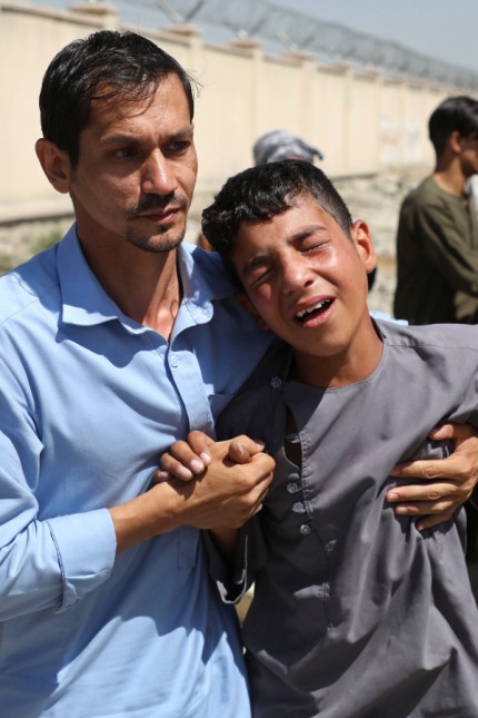 An Afghan boy mourns during the funeral of his brother after a suicide bomb blast at a wedding in Kabul