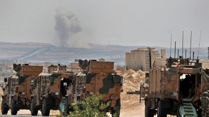 Syrien: Türkische Militärfahrzeuge in der nordsyrischen Provinz Idlib, während im Hintergrund Rauch aufsteigt.