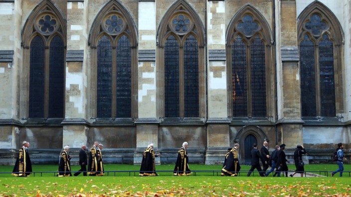 Golden Autumn leaves are on the ground as Supreme Court Judges looking resplendent in their black ro