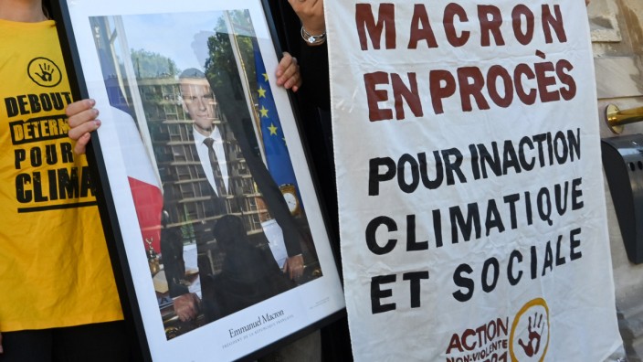 Emmanuel Macron: Aktivisten posieren in Saint-Ouen mit einem abgehängten Macron-Foto.