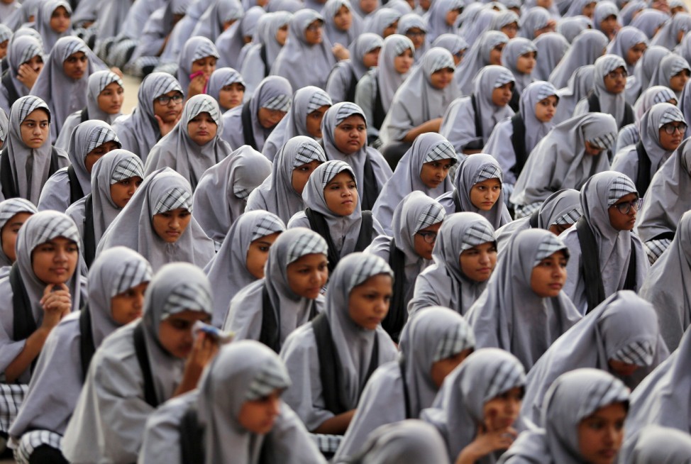 School girls listen to their teacher during a lecture on the Article 370 at a school in Ahmedabad