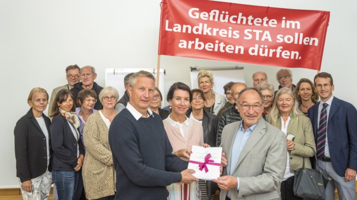Unterschriftensammlung: Im Namen von 14 Helferkreisen übergeben (vorne) Martin Lehmann-Dannert und Claudia Steinke die Petition an Landrat Karl Roth (rechts).