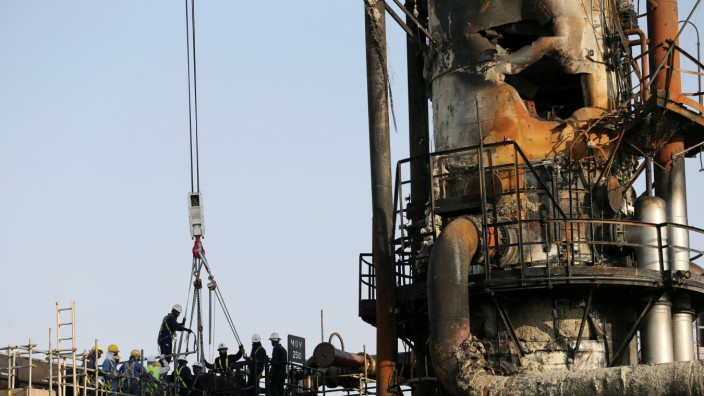 FILE PHOTO: Workers are seen at the damaged site of Saudi Aramco oil facility in Abqaiq