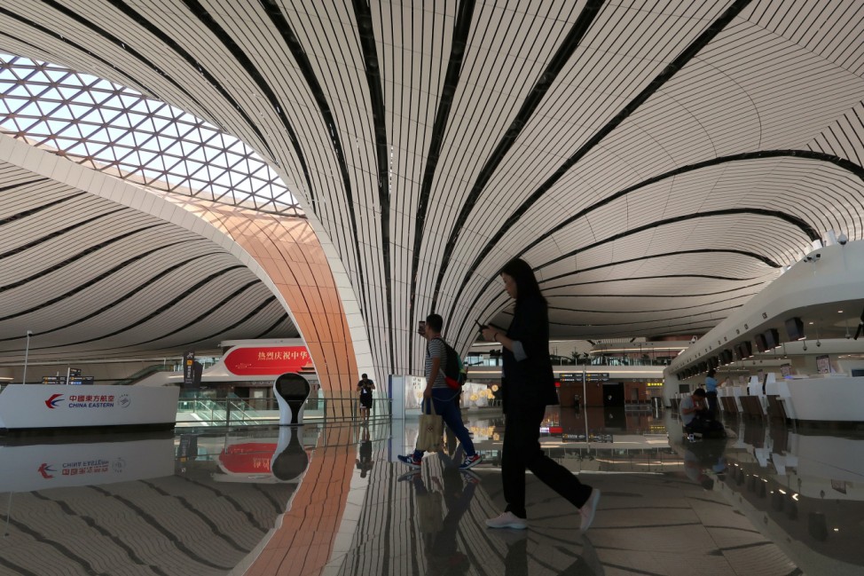 Journalists walk at the terminal hall after the launching ceremony for the new Daxing International Airport ahead of the 70th founding anniversary of the People's Republic of China in Beijing