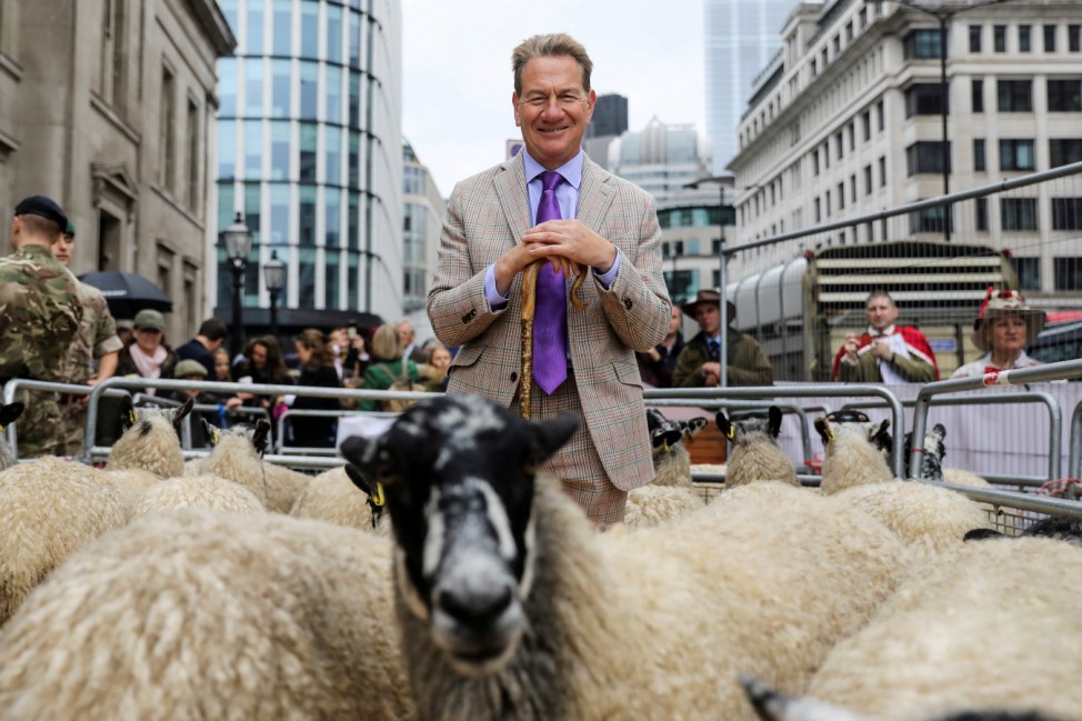 Television presenter and former Conservative MP Michael Portillo poses for a photograph with a  flock of sheep as he opens the wool fair by walking sheep across London Bridge in London