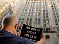 FILE PHOTO: Demonstrators hold protest signs as part of a demonstration in support of impeachment hearings in New York