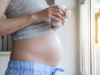 Close up of pregnant woman holding cup at the window model released Symbolfoto property released PUB