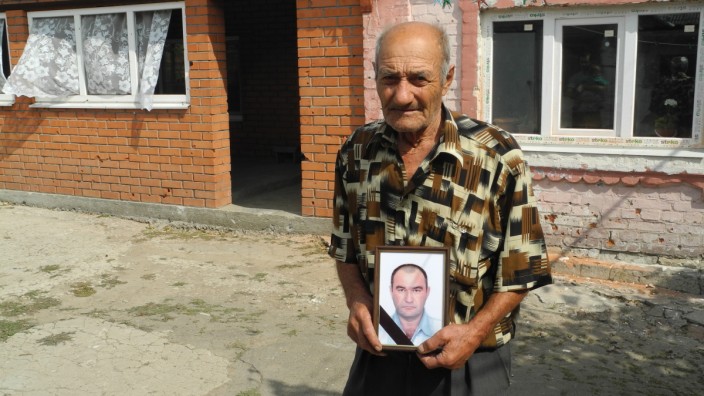 Ukraine-Krieg: Nikolaj Toki, 83, hält das mit Trauerflor geschmückte Bild seines toten Sohnes Iwan in der Hand.