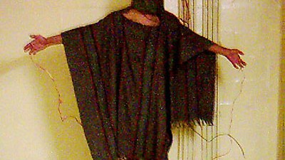 Fünf Jahre Abu Ghraib: Ein Symbolbild für Folter und Gewalt: Der verkabelte Abu-Ghraib-Häftling auf dem Karton (zum Vergrößern auf die Lupe klicken)