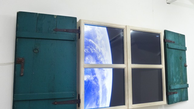 Ausstellung: Direkt und live aus der Raumstation ISS wird in einer Installation von Michael Acapulco ein Bild der Erde auf ein Fenster, das noch aus einer anderen Zeit stammt, projiziert.