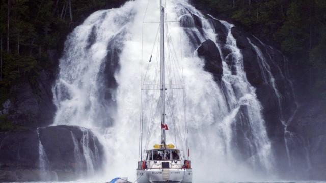 Segel-Kreuzfahrt in Kanada: Die Island Odyssey im Great Bear Rainforest vor einem Wasserfall.