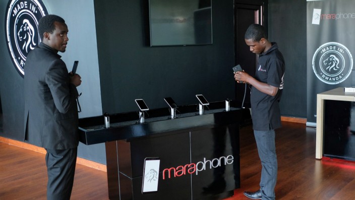 Workers display the Mara X and Mara Z smartphones during their launch by Rwanda's Mara Group in Kigali,