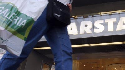Karstadt und Kaufhof: Passant mit Kaufhoftüte vor Karstadt-Filiale: Die beiden Einzelhandelskonzerne halten ihren Zusammenschluss zu einer "Deutschen Warenhaus AG" inzwischen für sinnvoll.