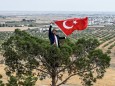 Türkei: Ein Mann hält an der Grenze zu Syrien eine türkische Flagge hoch