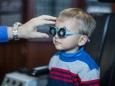 Boy doing eye test at optometrist model released Symbolfoto property released PUBLICATIONxINxGERxSUI