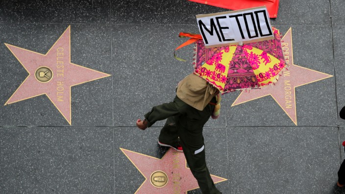 FILE PHOTO: A demonstrator takes part in a #MeToo protest march for survivors of sexual assault and their supporters in Hollywood, Los Angeles