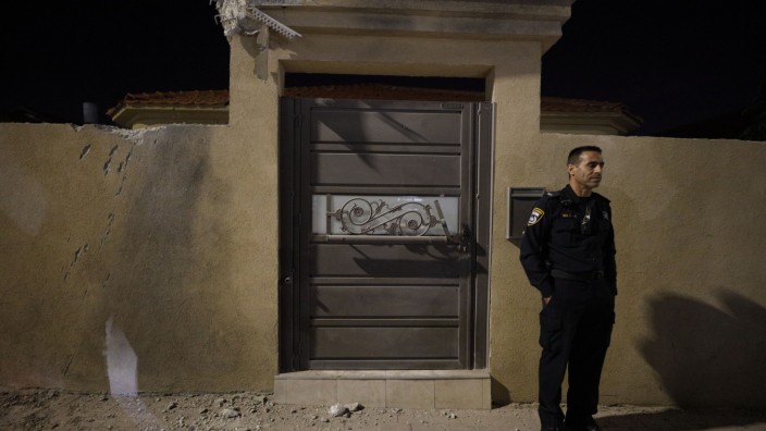 Nahost: Ein Polizist steht vor einem Haus in Sderot, das durch einen Raketanangriff aus dem Gazastreifen beschädigt wurde.