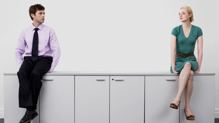 Young male and female business people sitting on office cabinets,model released, Symbolfoto,property released PUBLICATIO